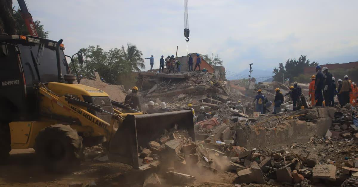 Rescatistas y una retroexcavadora remueven escombros de edificaciones colapsadas por el terremoto