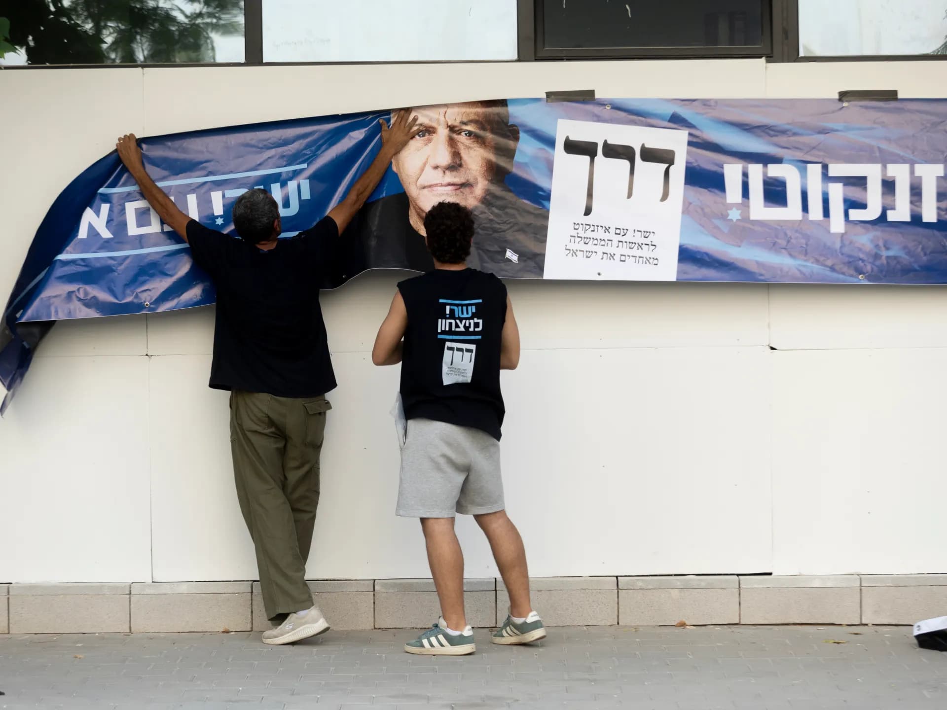 Simpatizantes del partido Yashar cuelgan un afiche de campaña de Gadi Eisenkot en Herzliya, Israel