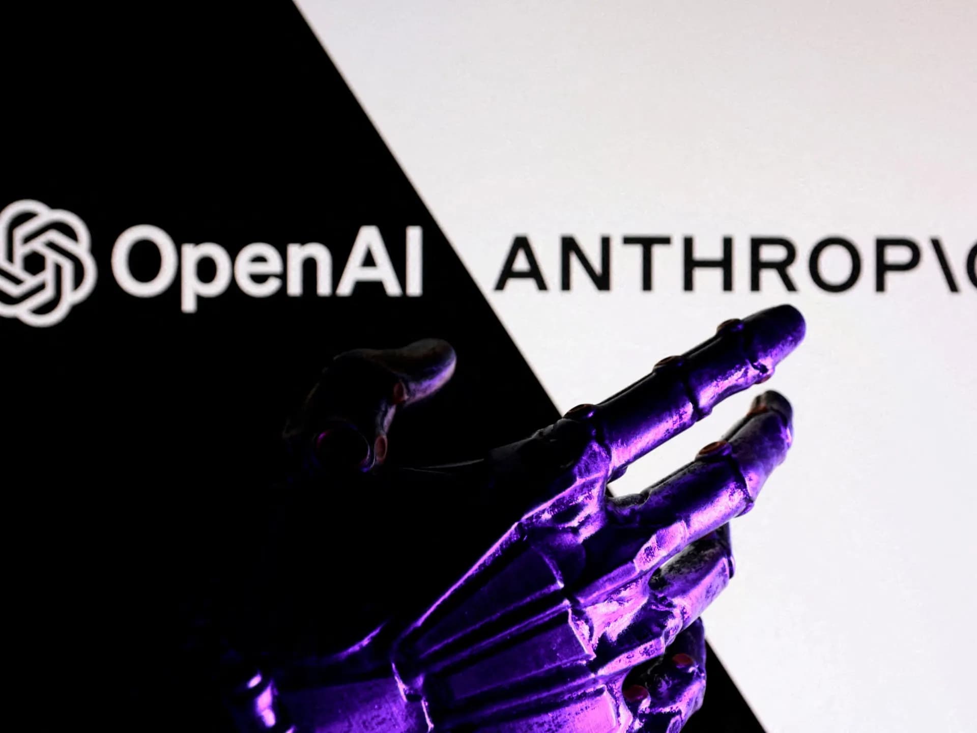 Mano robótica frente a los logotipos de OpenAI y Anthropic en una fotoilustración