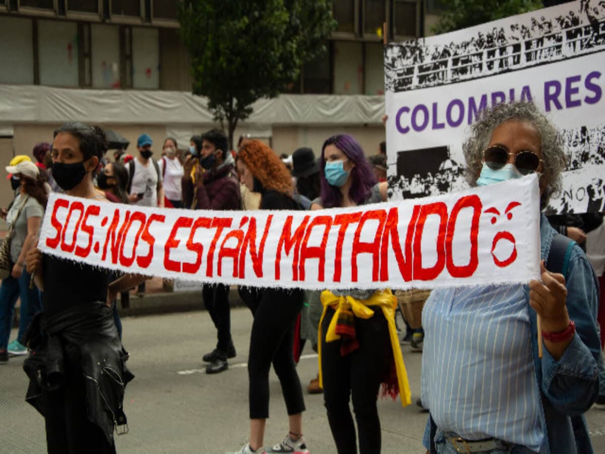 Manifestantes sostienen una pancarta con el mensaje «SOS: nos están matando» durante una marcha (foto de archivo)