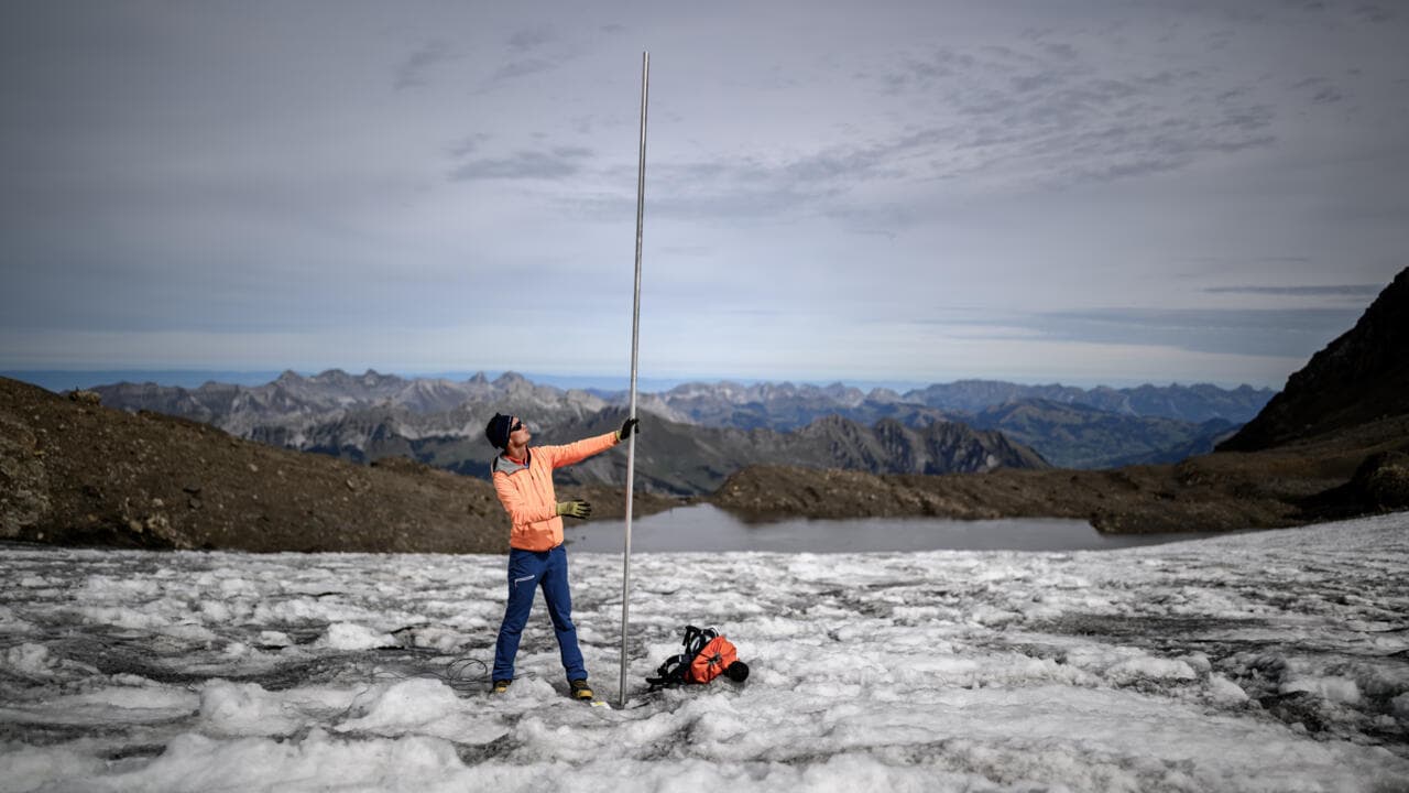 El glaciólogo Matthias Huss junto a una estaca de medición sobre el glaciar Scex Rouge, en los Alpes suizos