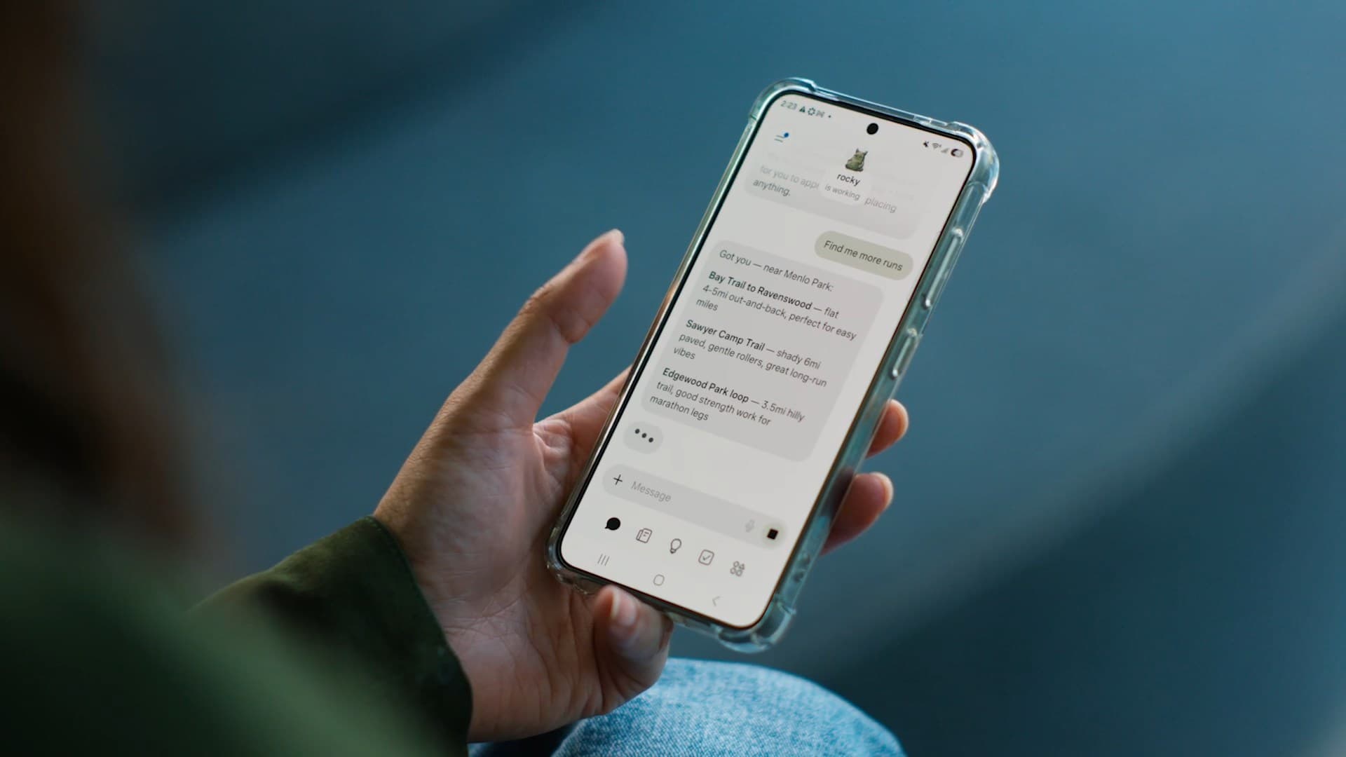 Una persona sostiene un teléfono móvil con una conversación abierta en la pantalla