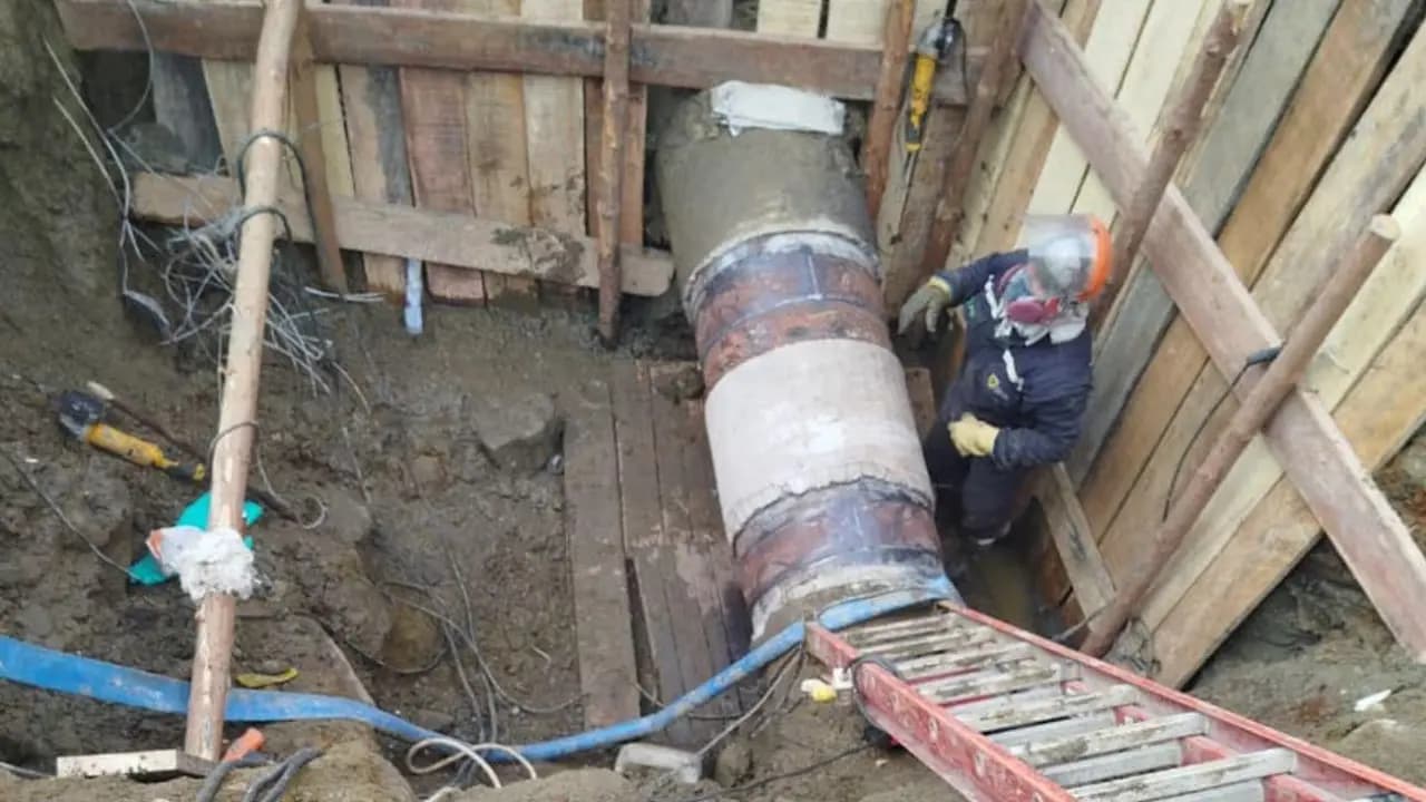 Un trabajador junto a la tubería rota en una excavación en el nororiente de Medellín