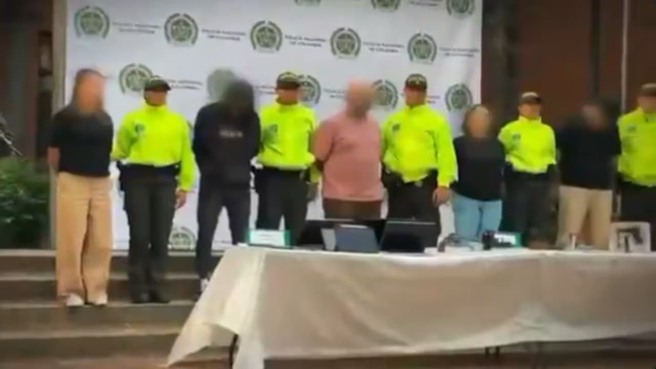 Uniformados de la Policía Nacional presentan a los capturados frente a un panel institucional