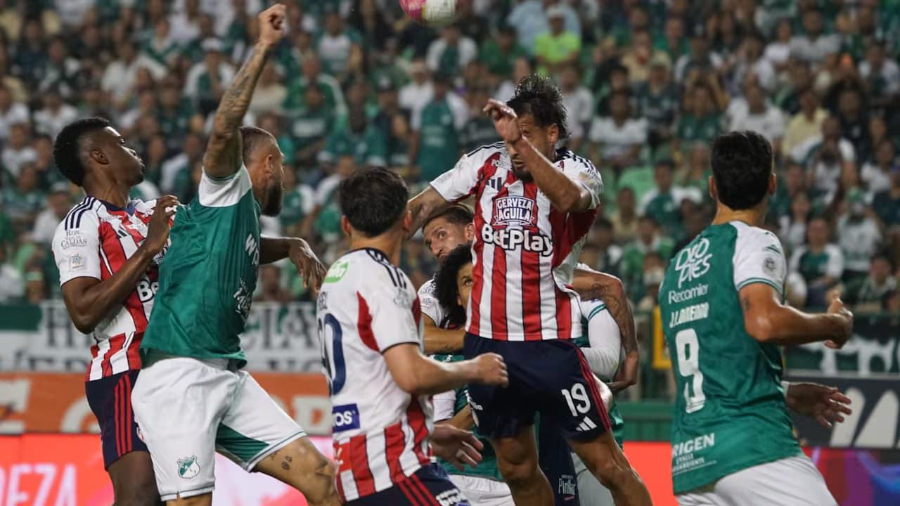 Jugadores del Deportivo Cali y del Junior disputan un balón aéreo en el estadio de Palmaseca