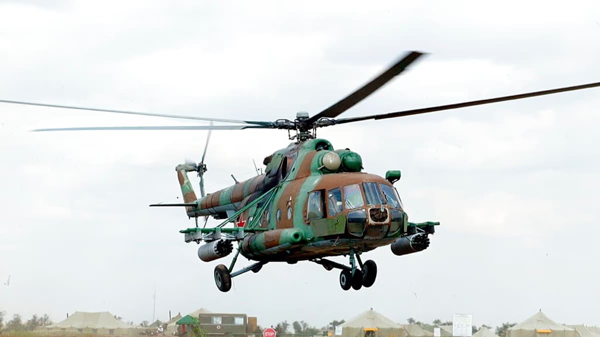 Un helicóptero militar ruso Mi-8 de camuflaje verde y marrón en vuelo sobre un campamento