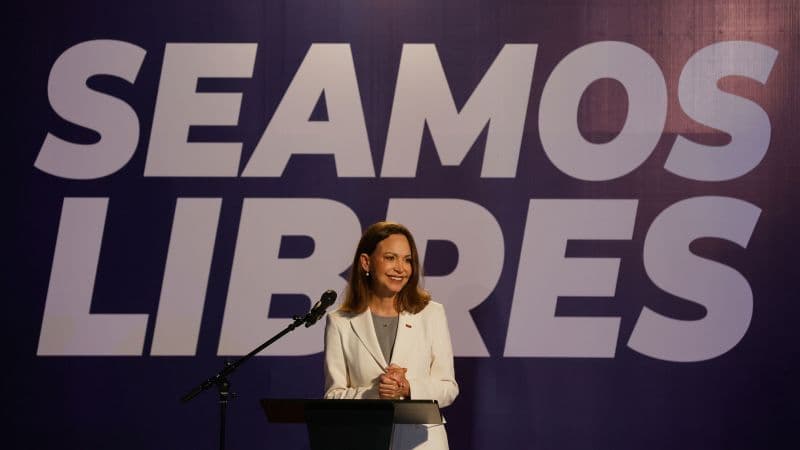 María Corina Machado en su rueda de prensa en Caracas, frente a un fondo con la frase «Seamos libres»