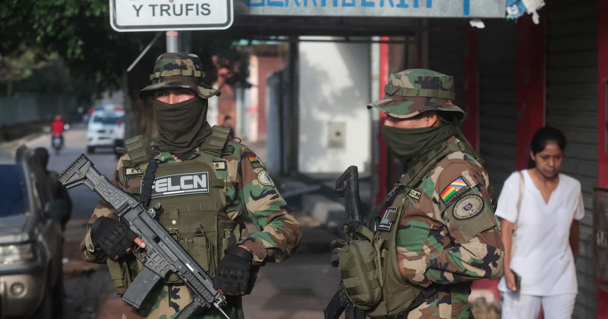 Agentes antinarcóticos de la Felcn, armados y encapuchados, patrullan una calle en Bolivia