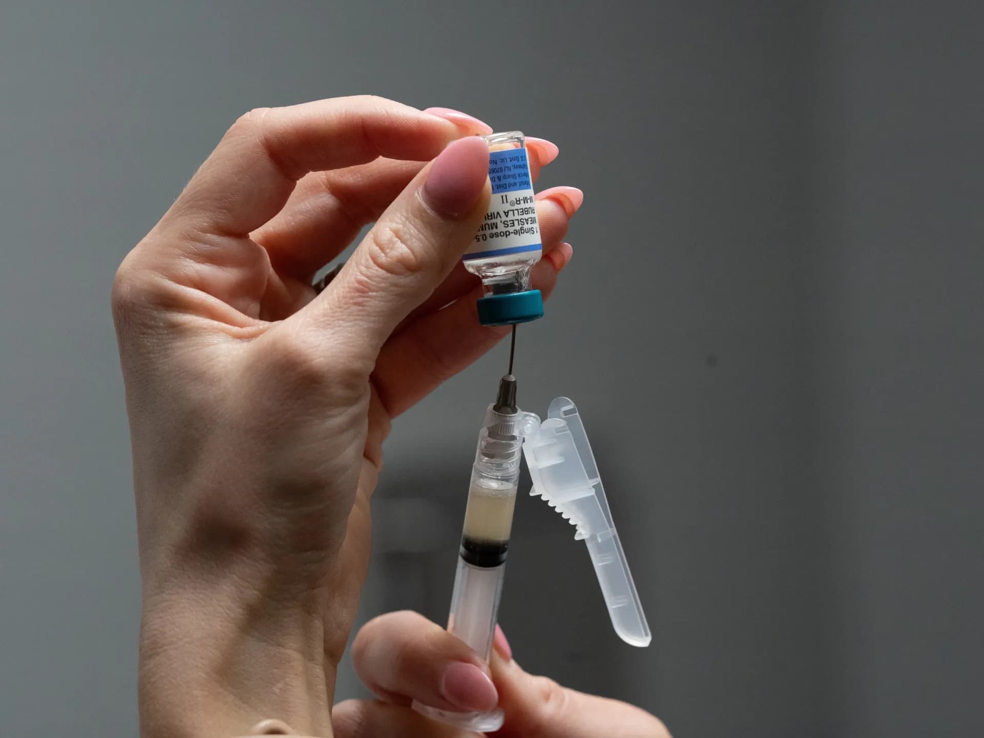 Una trabajadora de la salud prepara una dosis de la vacuna triple viral contra sarampión, paperas y rubéola