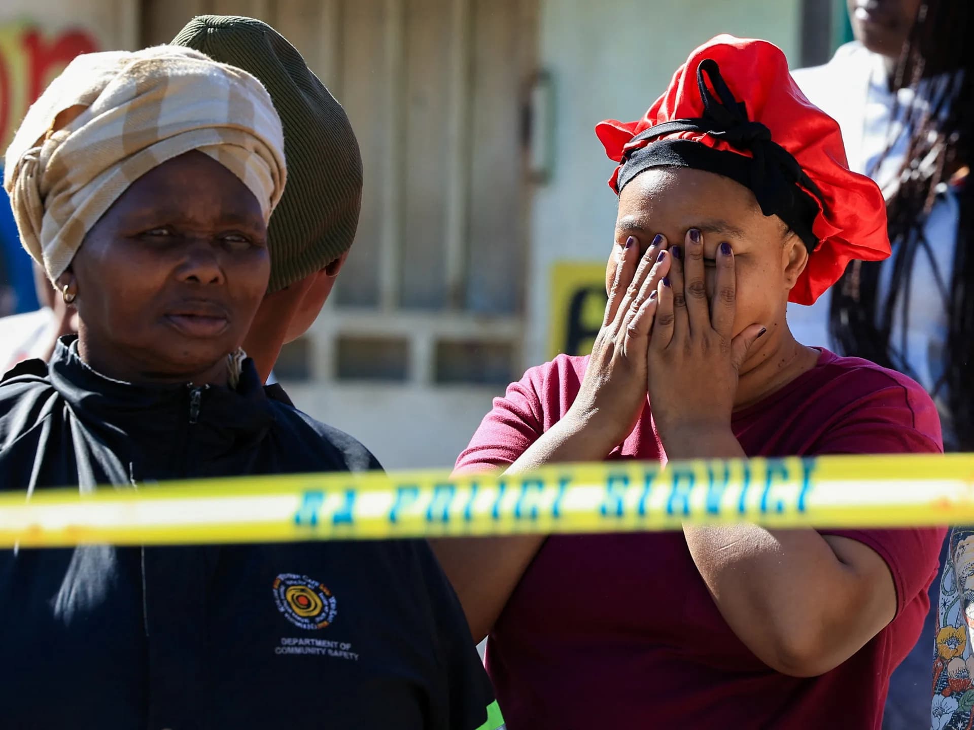 Vecinas junto al cordón policial en el lugar de uno de los tiroteos en Sudáfrica