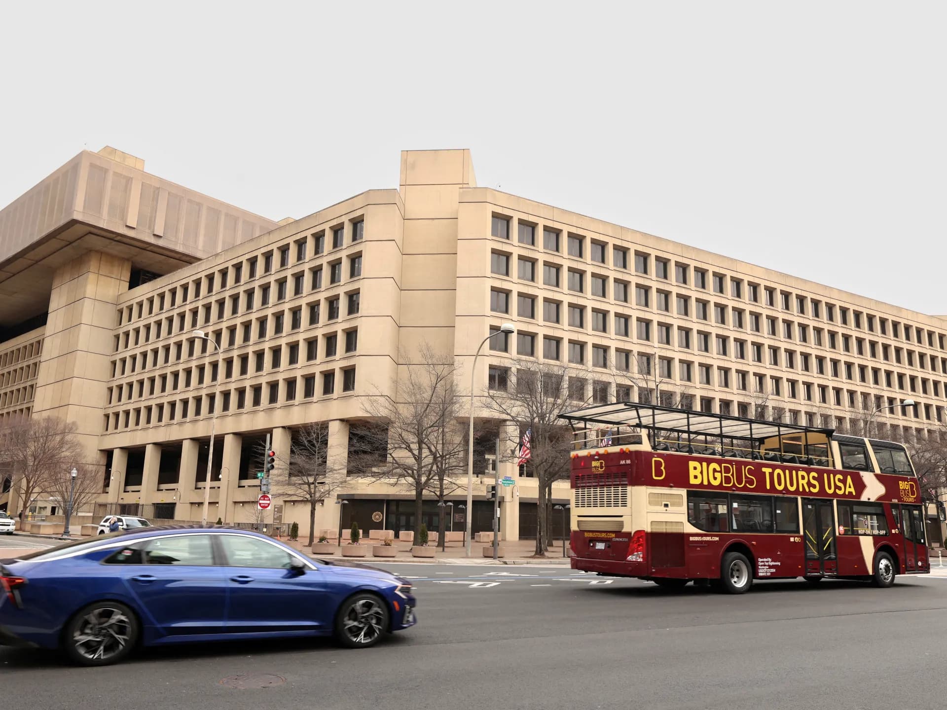 Sede del FBI en Washington, frente a la que pasan un automóvil y un bus turístico