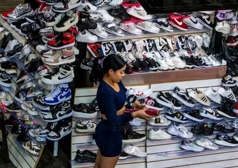Una vendedora organiza calzado en un local comercial