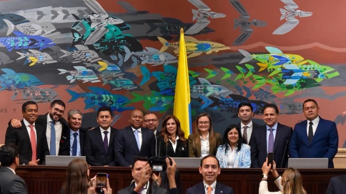 Los magistrados electos del Consejo Nacional Electoral posan en el recinto del Congreso junto a la bandera de Colombia