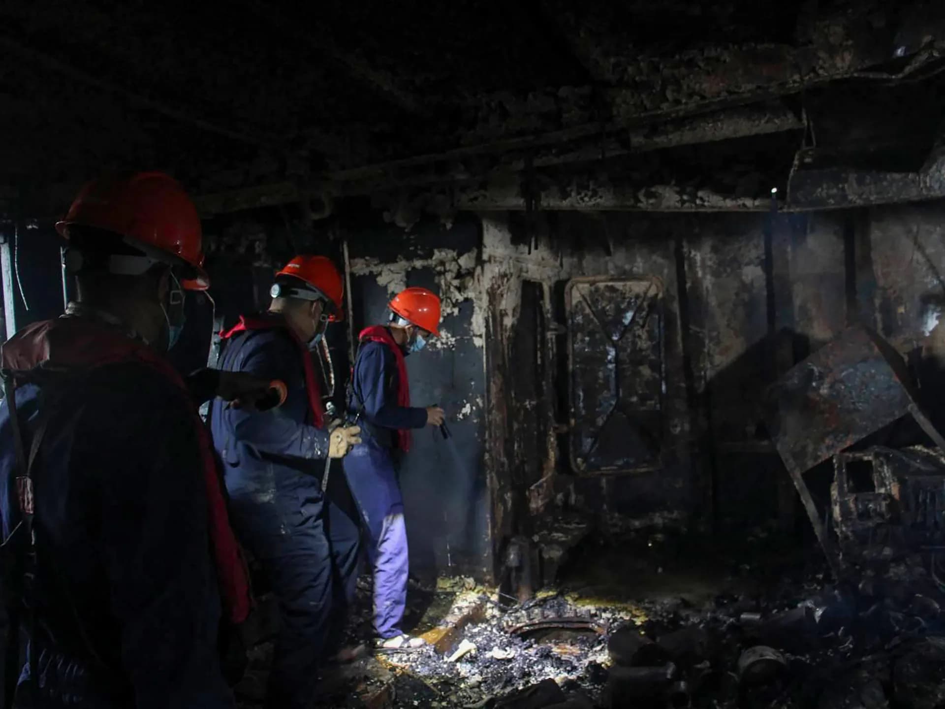 Personal de la guardia costera inspecciona una sección quemada del transbordador frente a Palawan