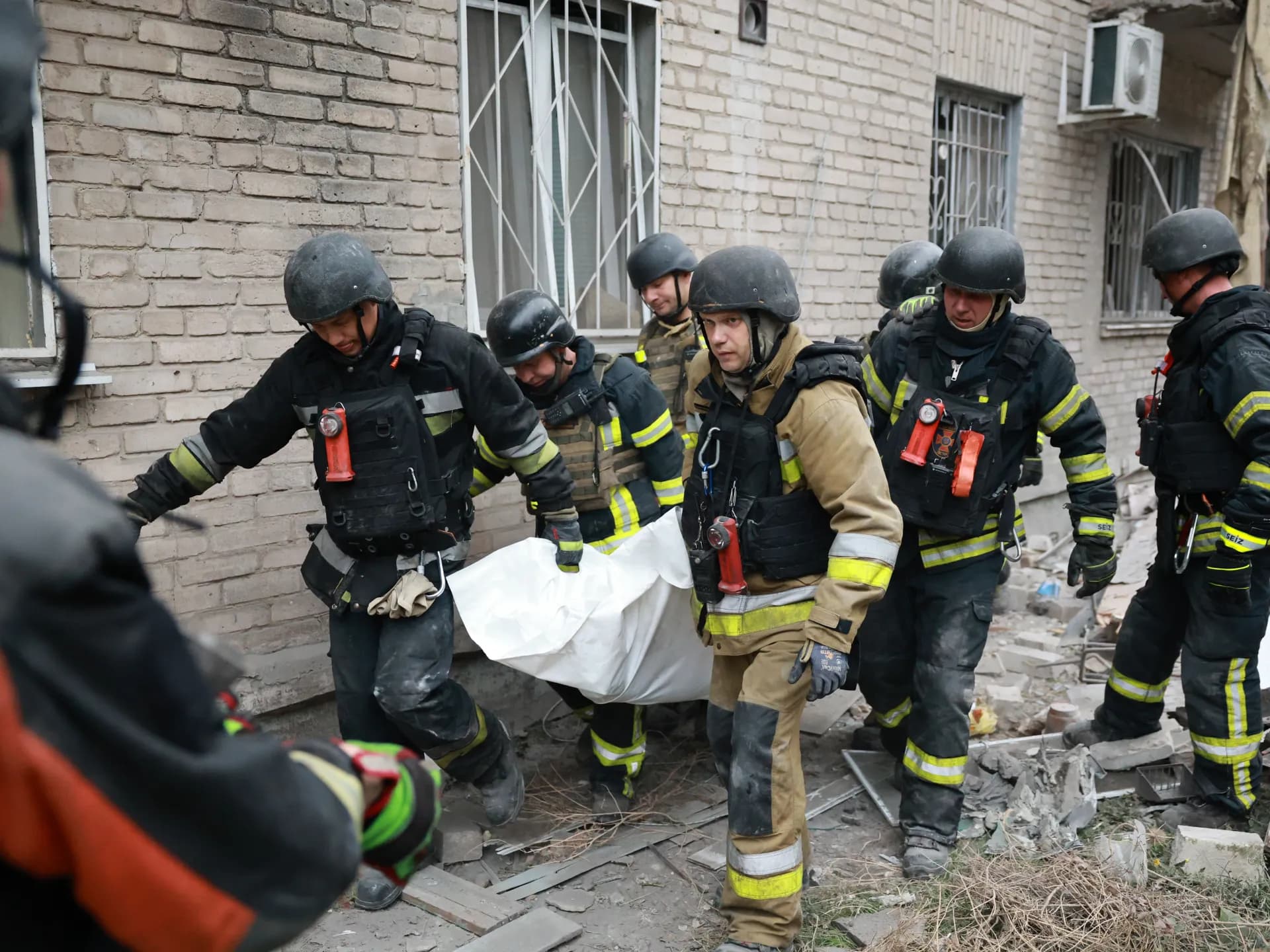 Rescatistas ucranianos sacan un cuerpo de un edificio residencial alcanzado por un ataque ruso en Zaporiyia