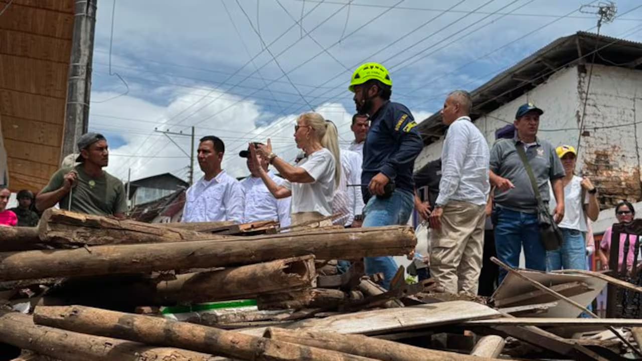 La gobernadora del Valle del Cauca y un grupo de funcionarios recorren una calle cubierta de escombros y maderas