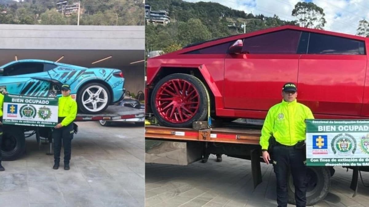 Dos uniformados de la Policía sostienen carteles de «bien ocupado» junto a un Corvette azul turquesa y una Tesla Cybertruck roja cargados en plataformas