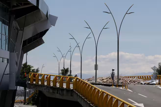 Fachada del aeropuerto Matecaña de Pereira con la estructura metálica desprendida y escombros junto a la vía de acceso