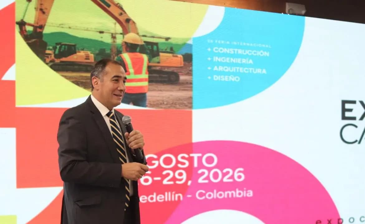Un vocero de la feria habla ante la pantalla con la marca y las fechas de Expocamacol 2026 durante la presentación del certamen
