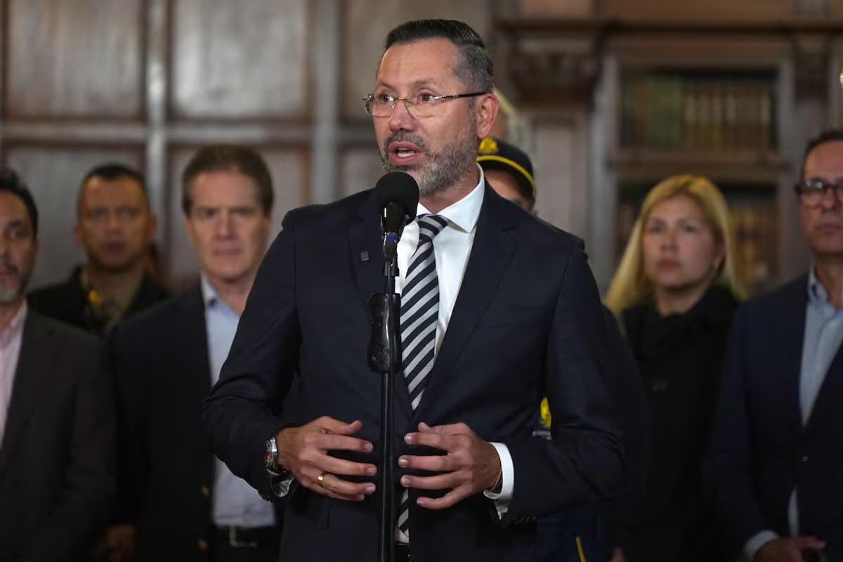 El ministro de Vivienda, Jaime Andrés Beltrán, habla ante un micrófono rodeado de funcionarios