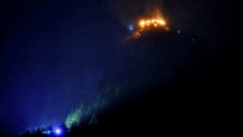 El Kehlsteinhaus, en la cima de una montaña cerca de Berchtesgaden, envuelto en llamas en la noche, con luces de emergencia al pie