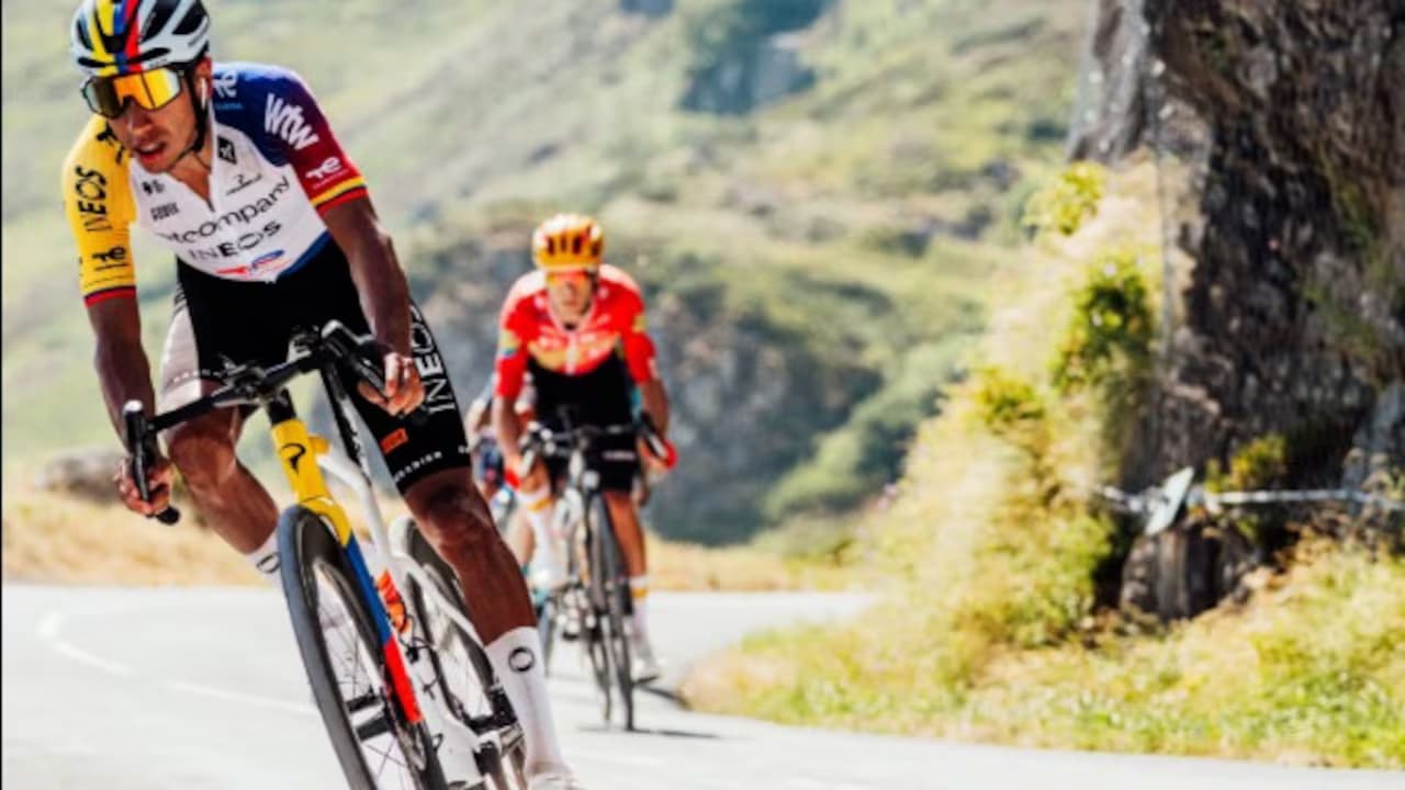 Un ciclista encabeza la marcha por una carretera de montaña seguido por otros corredores