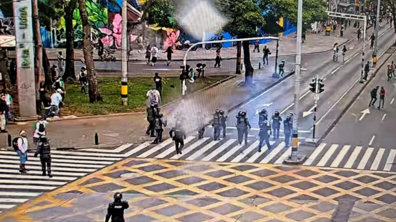 Agentes antidisturbios de la Policía avanzan por un cruce vial junto a la Universidad de Antioquia, en Medellín