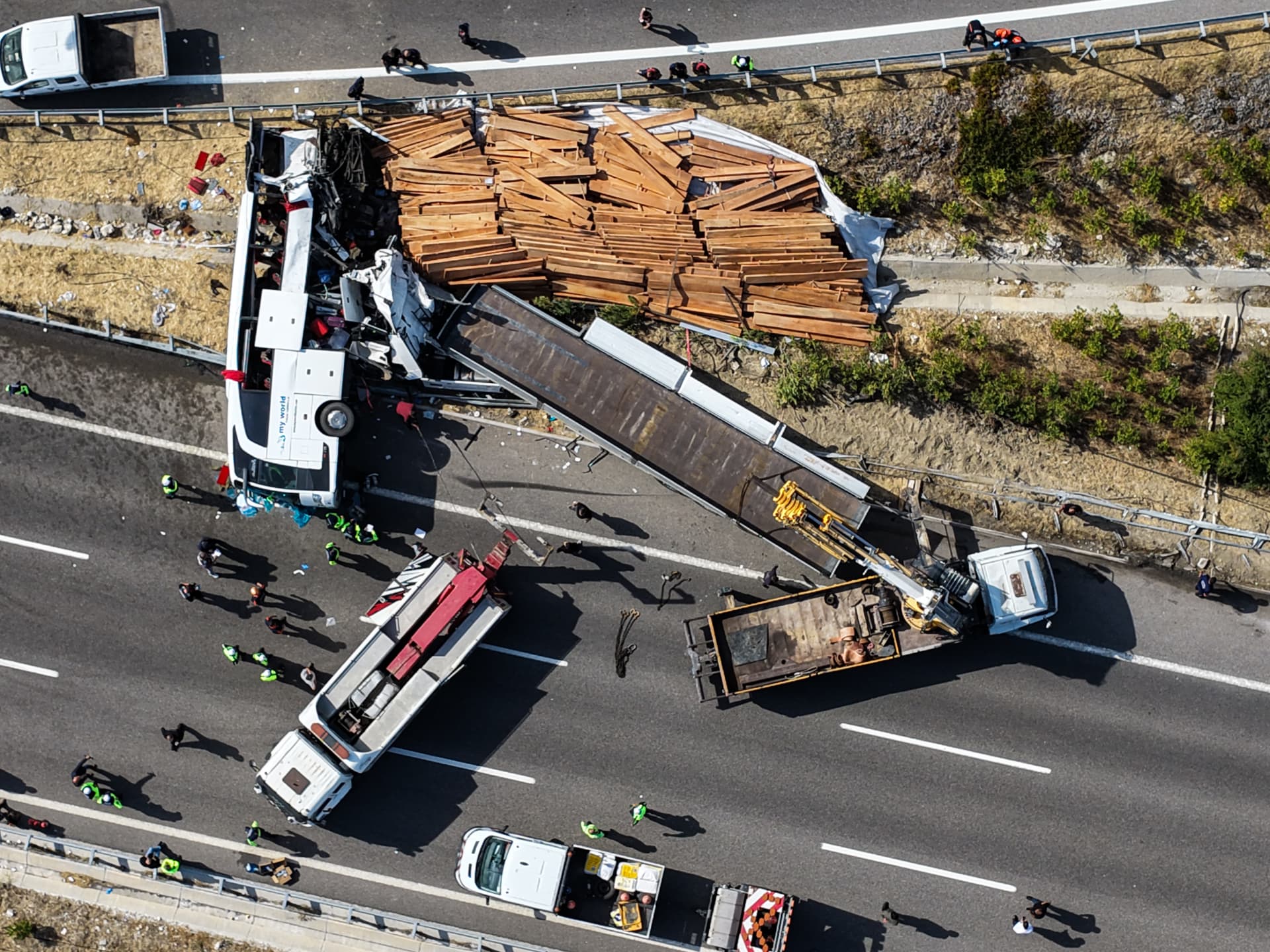 Vista aérea del bus volcado junto al camión y su carga de tablones de madera en la autopista cerca de Akhisar
