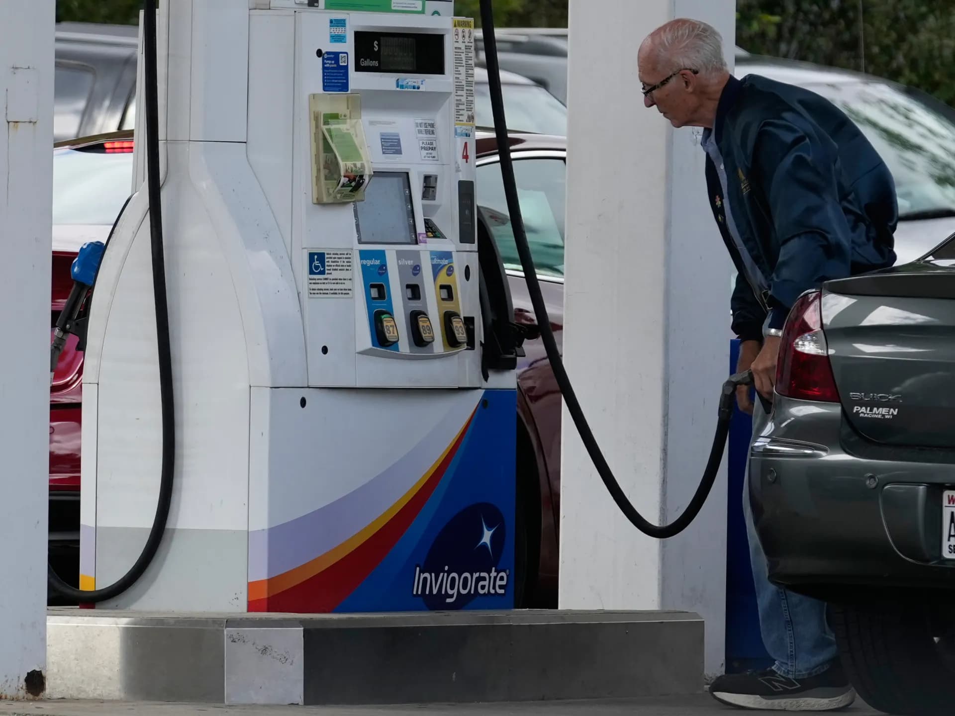 Un conductor revisa el precio mientras tanquea en una estación de Wisconsin