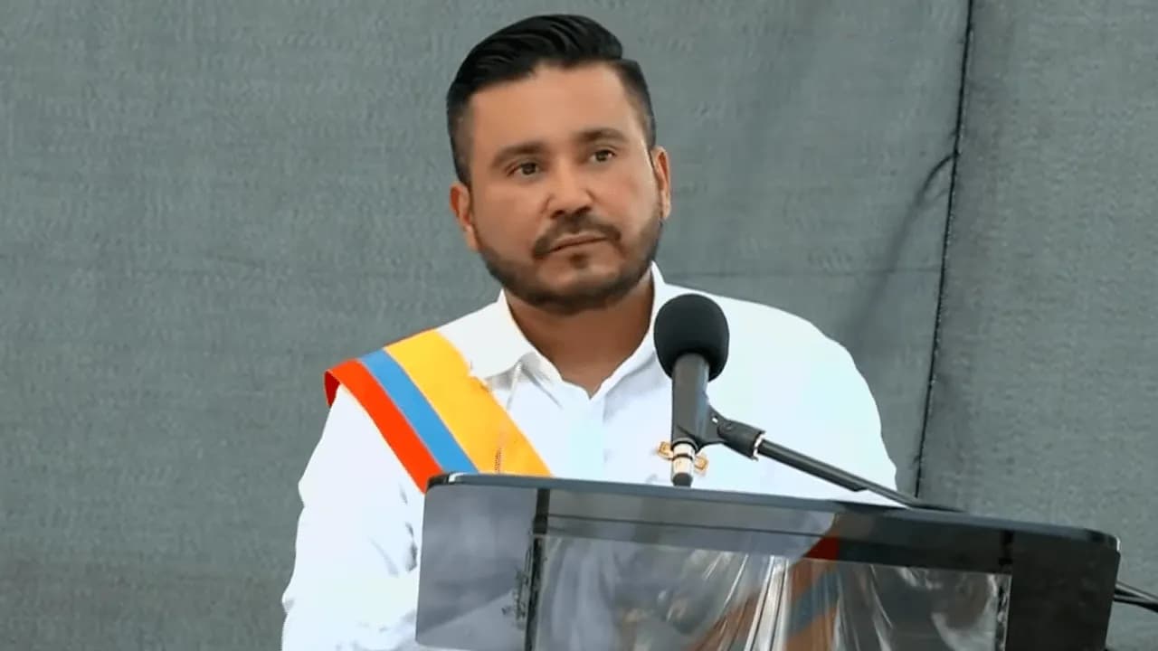 Jorge Eliécer Laverde, con banda tricolor sobre camisa blanca, habla ante un micrófono en el acto de posesión