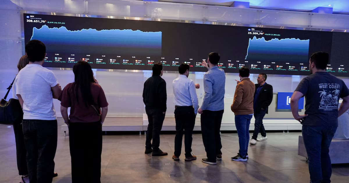 Un grupo de personas observa en una pantalla gigante de la Bolsa de São Paulo la subida del índice Ibovespa