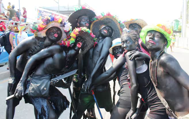 Bailarines del Son de Negro, con el cuerpo pintado y machetes de madera, durante el festival