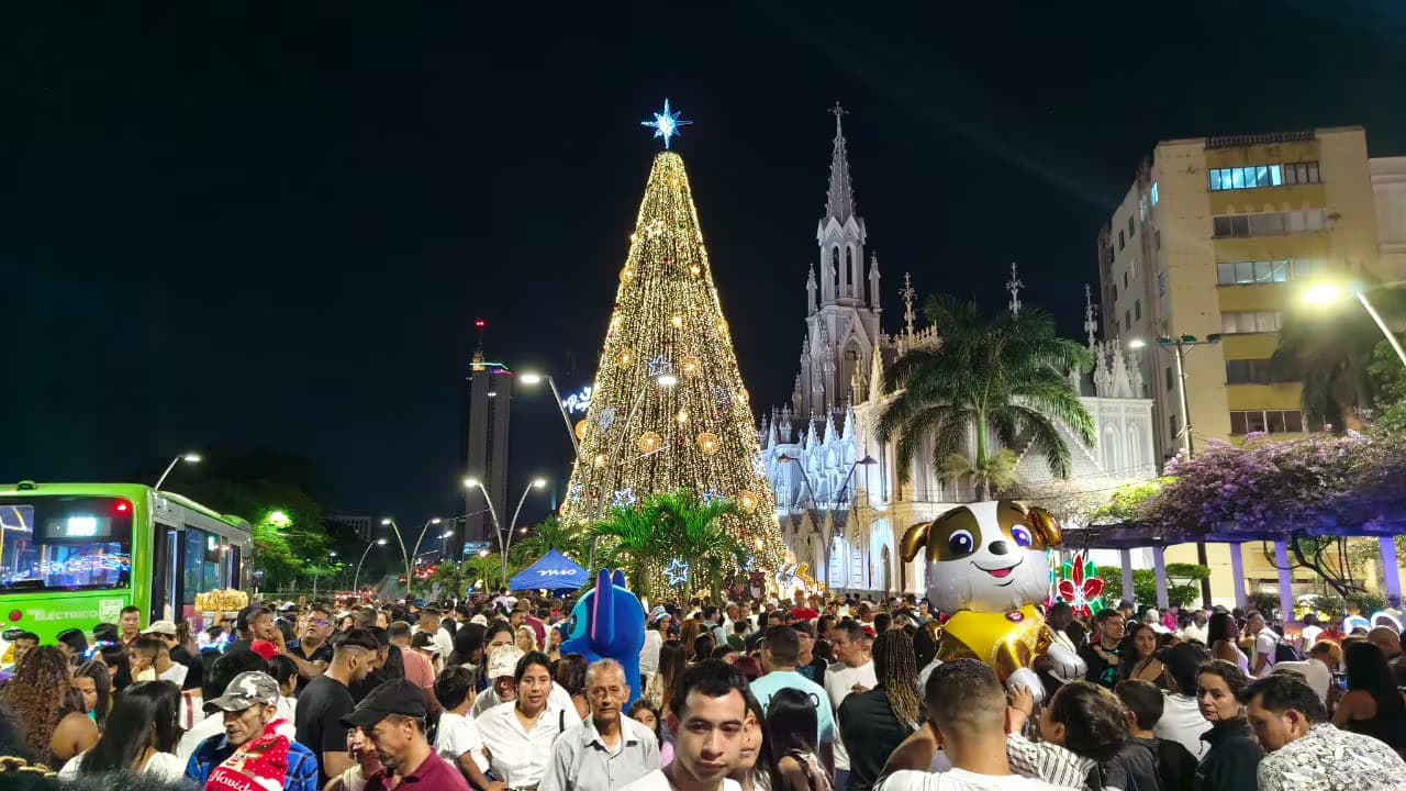 Multitud frente a un árbol de Navidad iluminado junto a la iglesia La Ermita, en Cali