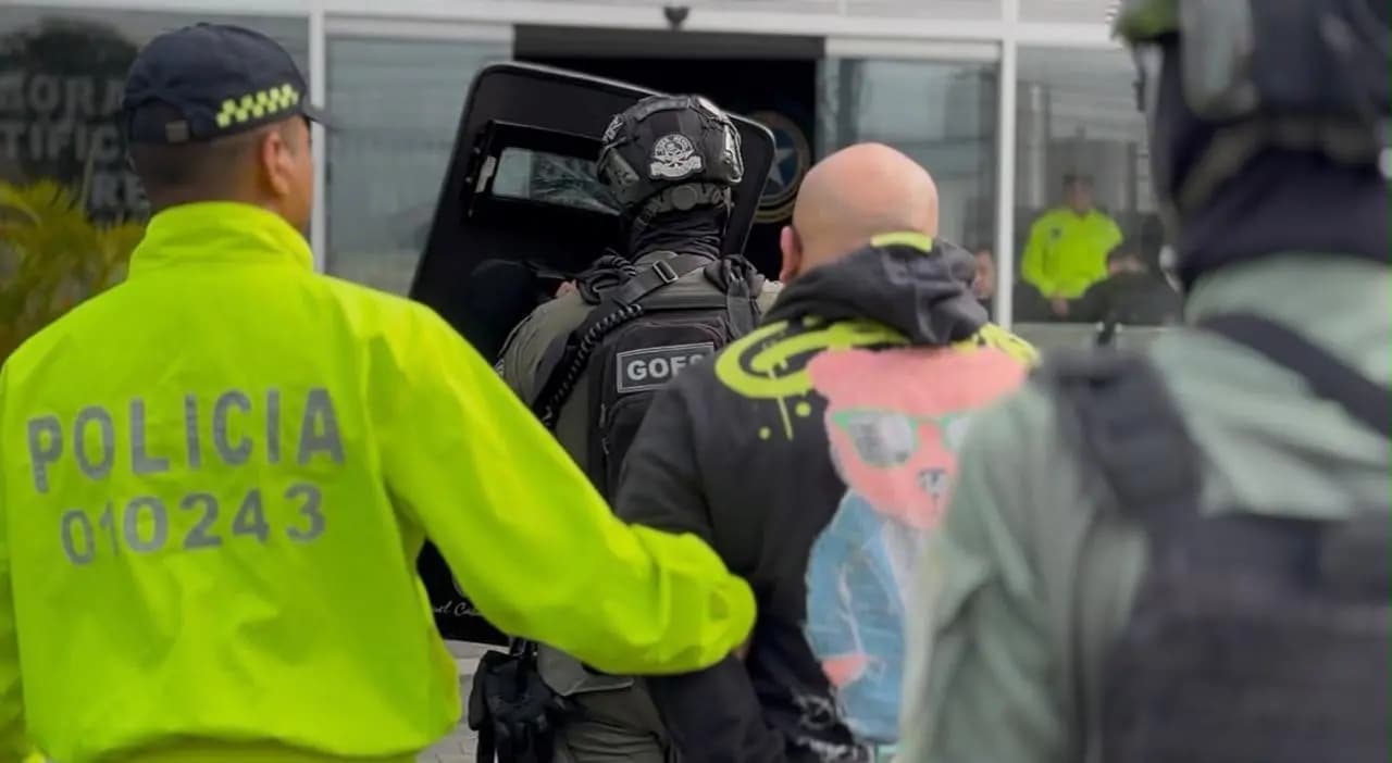 Agentes de la Policía conducen a un capturado durante el operativo en Medellín