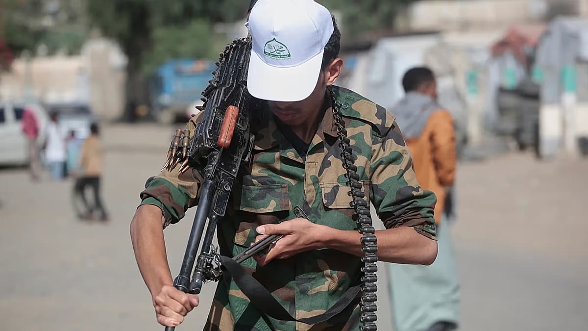 Un combatiente armado camina por una calle en Yemen