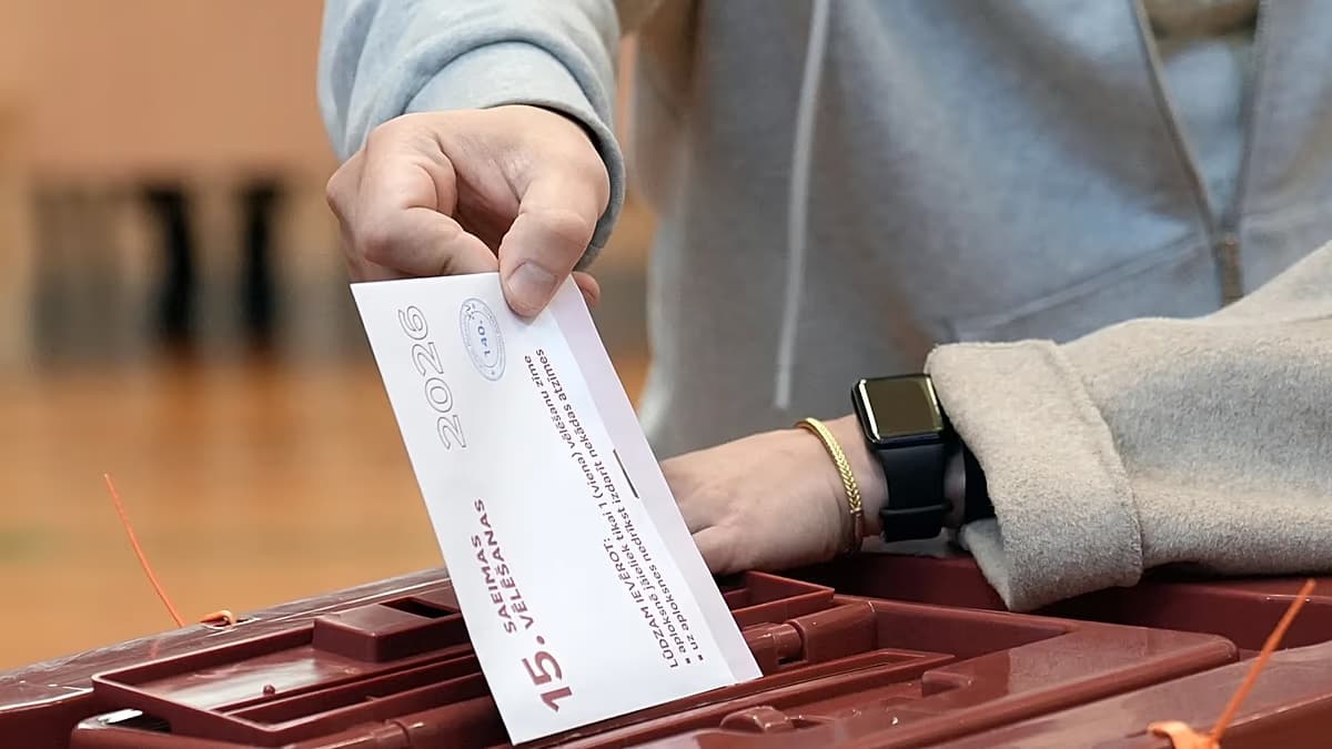 Un votante deposita su sobre en una urna durante las elecciones parlamentarias de Letonia