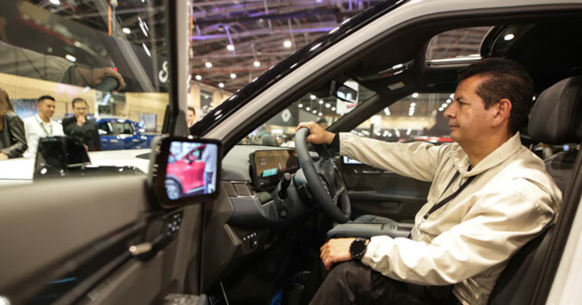 Un visitante prueba un vehículo en una feria automotriz