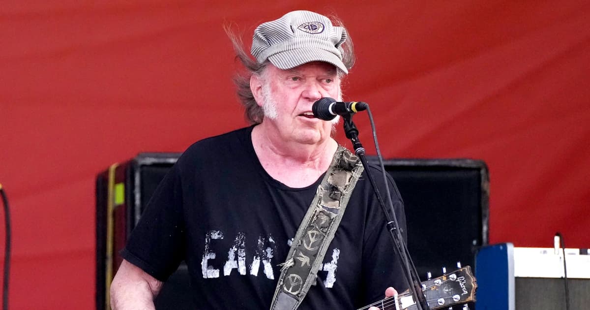 Neil Young canta y toca la guitarra durante un concierto
