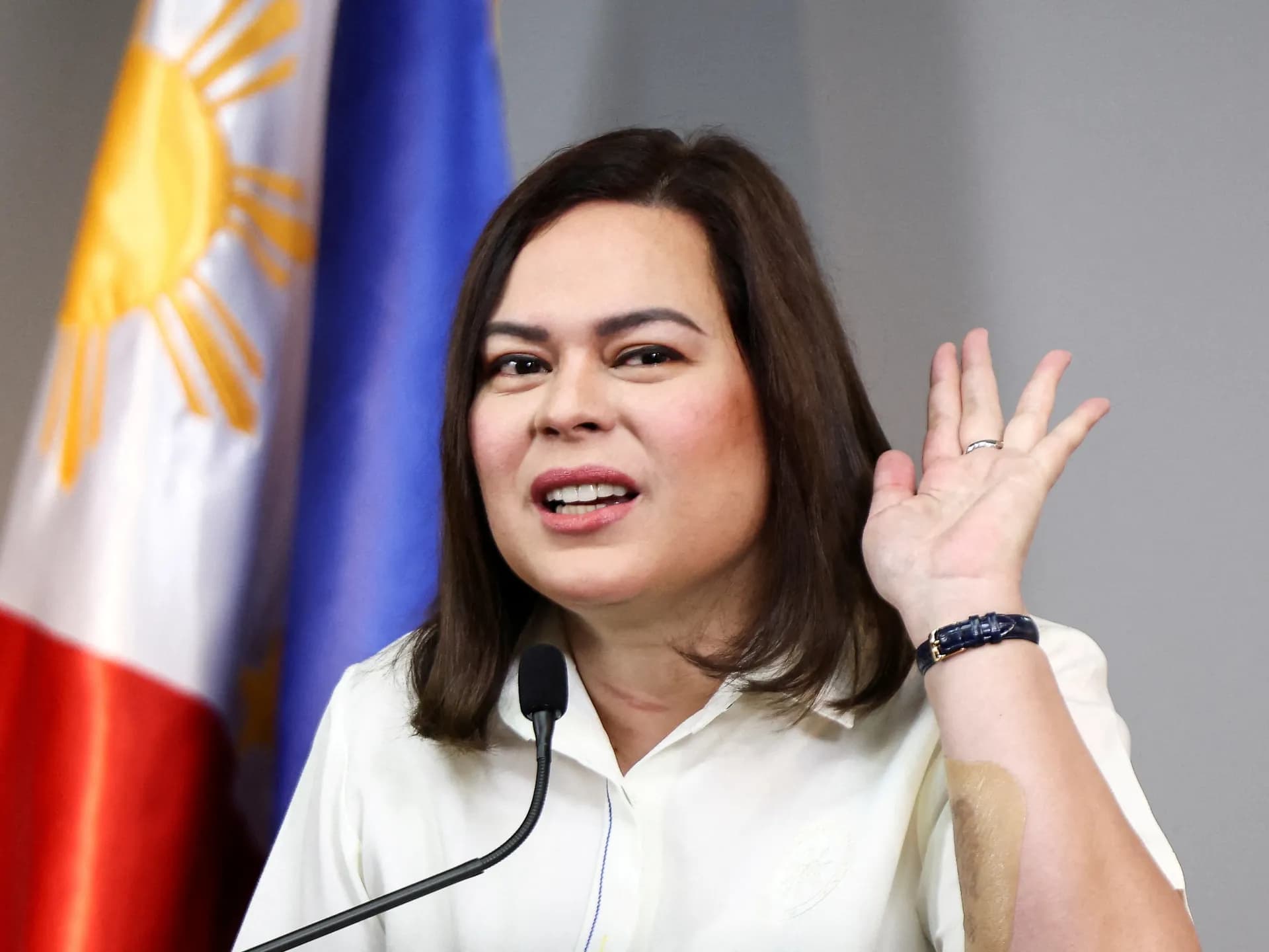 La vicepresidenta de Filipinas, Sara Duterte, habla en una rueda de prensa junto a la bandera nacional