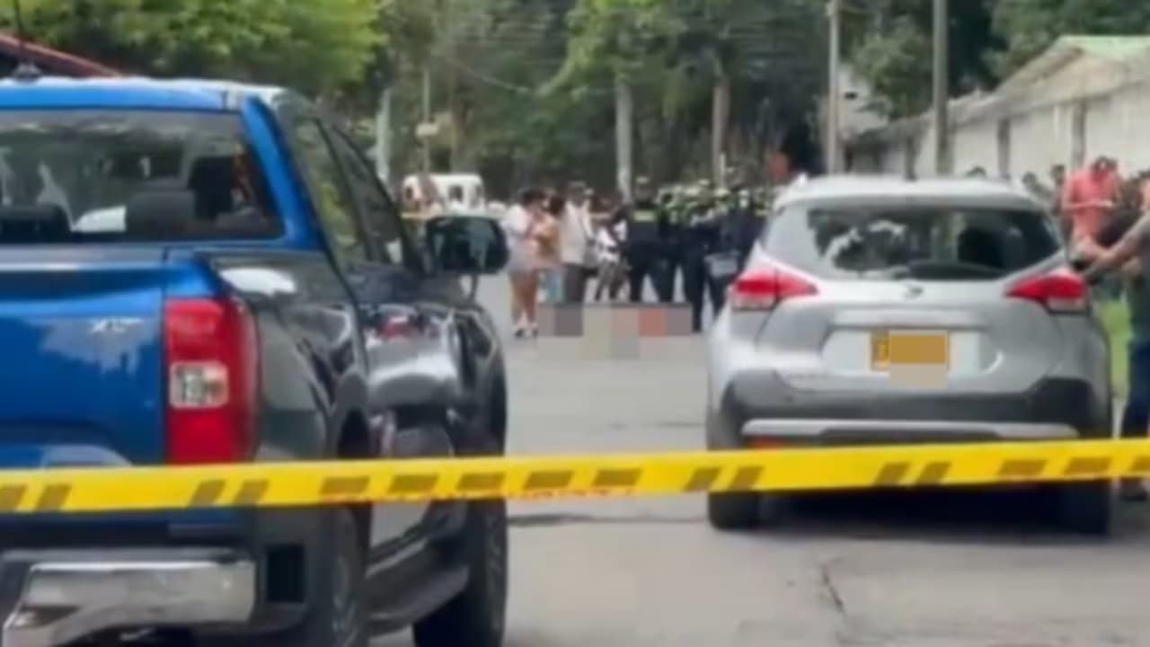 Policías y curiosos tras una cinta de acordonamiento en una calle de Palmira