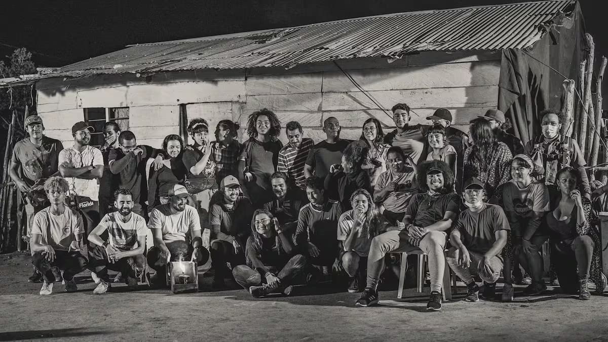 El equipo de rodaje de 'El bovino de los cuernos curvos' posa de noche frente a una casa de madera