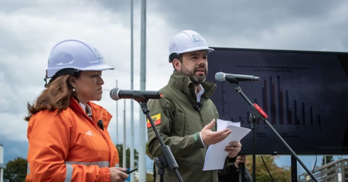 El alcalde de Bogotá, con casco del Acueducto, habla ante micrófonos junto a la gerente de la empresa