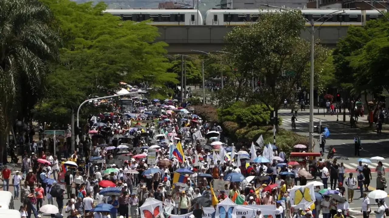 Manifestantes marchan por una avenida de Medellín bajo el viaducto del metro, en una movilización anterior