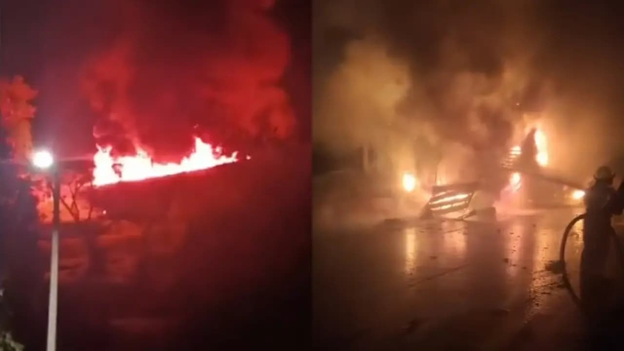 Llamas y humo sobre el tractocamión incendiado en el puente Helicoidal mientras un bombero lanza agua