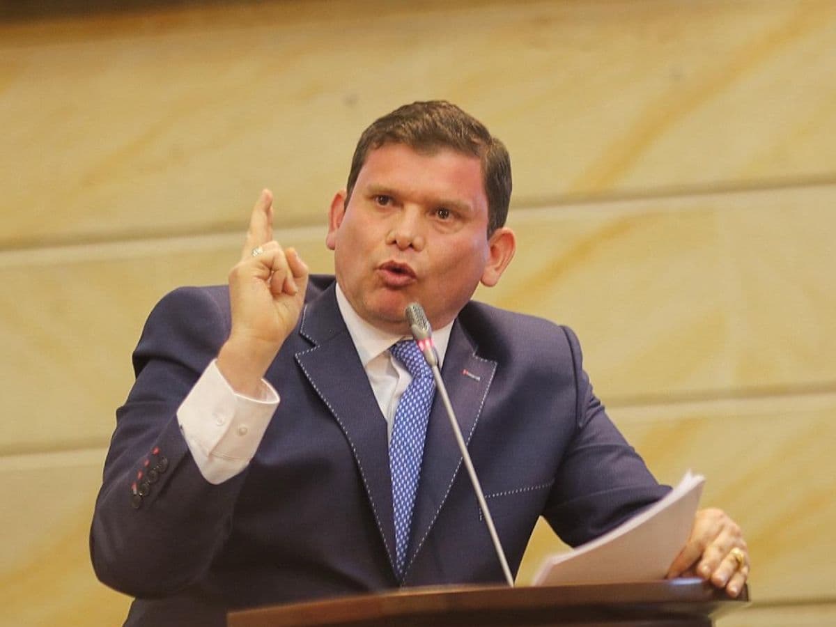 John Milton Rodríguez habla desde un atril con papeles en la mano.