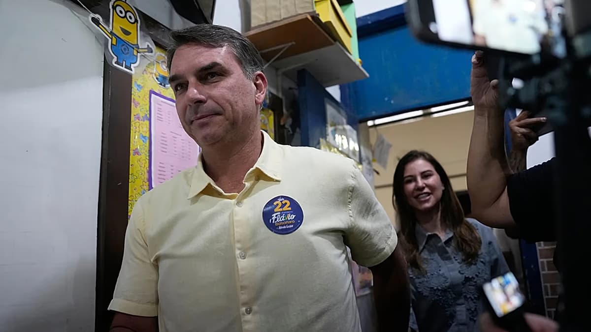 Flávio Bolsonaro, con una camisa amarilla y un distintivo de campaña, en un puesto de votación
