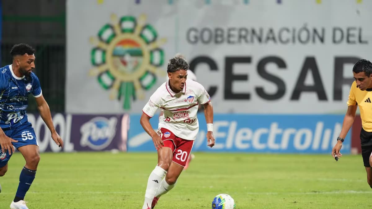 Un jugador de Junior conduce el balón ante un rival de Alianza Valledupar en el estadio Armando Maestre Pavajeau