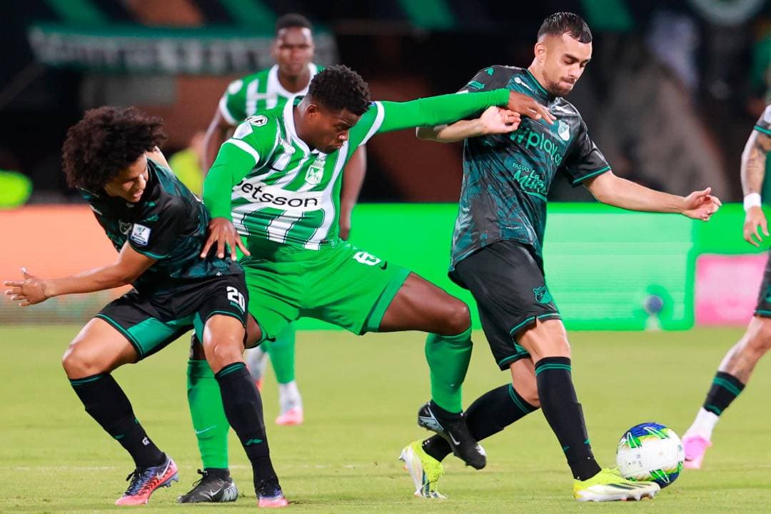 Un jugador de Atlético Nacional protege el balón entre dos rivales del Deportivo Cali en el césped del Atanasio Girardot