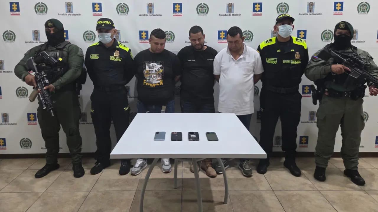 Los tres capturados custodiados por uniformados durante la presentación del operativo