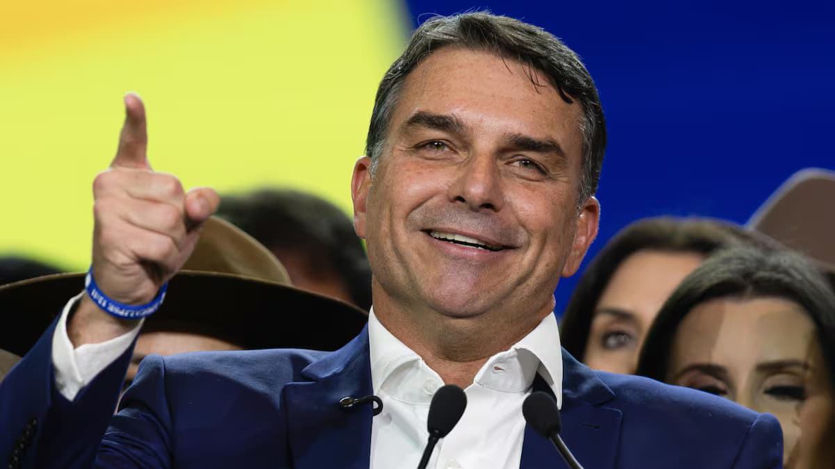 Flávio Bolsonaro sonríe y levanta el índice durante un acto de campaña